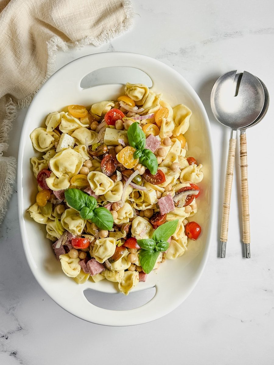 Tortellini salad with tomatoes, ham, and basil.